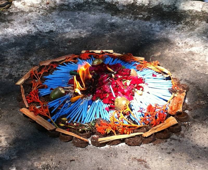 Feuerritual mit blauen Kerzen, Blüten und Früchten